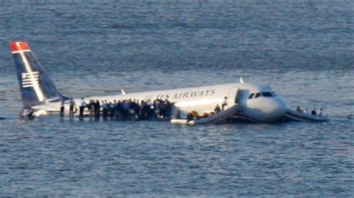 Passengers stand on the wings of a U.S. Airways plane as a ferry pulls up to it after it landed in the Hudson River in New York